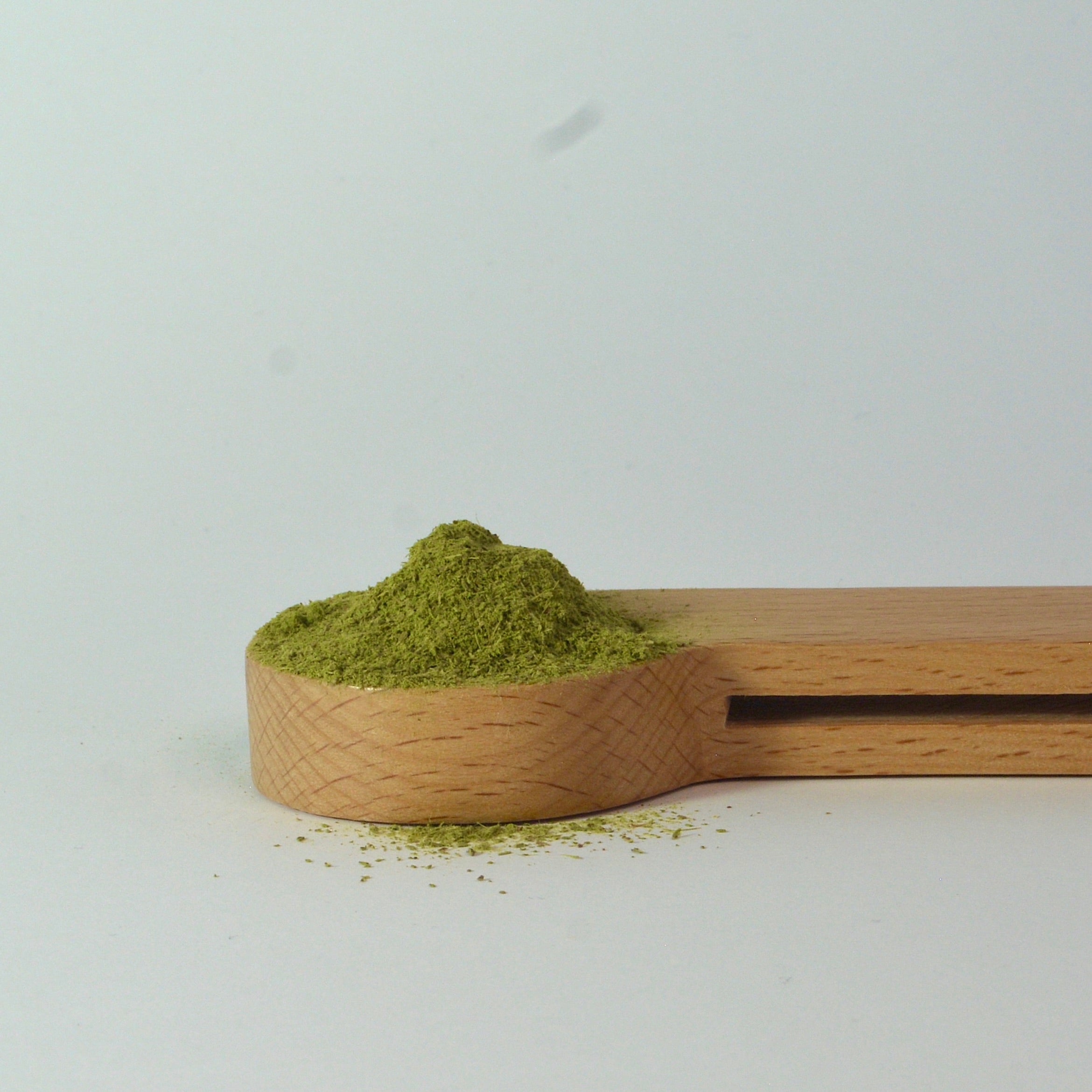 organic certified Manuka Leaf powder in a wooden spoon. Product of New Zealand 